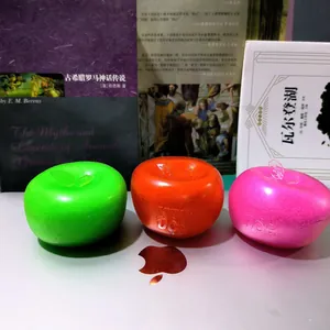 Three colorful apple-shaped squishy toys in green, orange and pink