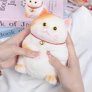 Detailansicht einer Hand, die ein süßes weißes Maneki-neko Katzen-Squishy-Spielzeug drückt