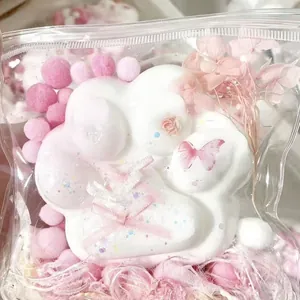 Close-up of white silicone cat paw squishy toy with pink ribbon and butterfly detail