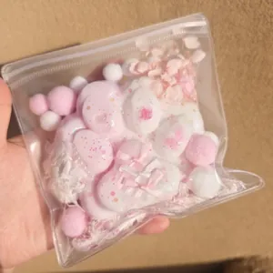 Detailed view of a cute pink cat paw squishy toy in a decorative bag with bows and flowers