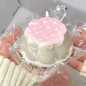 Detailed view of a pink and white dessert-shaped silicone squishy toy in clear packaging.