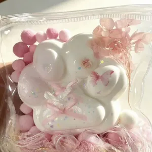Close-up of white silicone cat paw squeeze toy with pink ribbons and butterfly design.