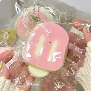 Close-up of squishy bread toy with pink frosting in plastic packaging