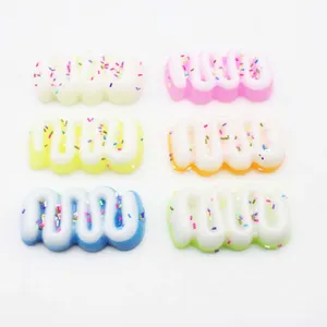 Detail van zes kleurrijke, crèmevormige squishy speeltjes op een witte achtergrond.