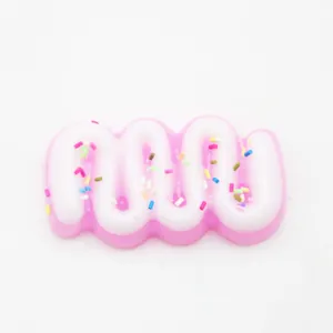Macro-opname van een roze en wit golvend crème squishy speeltje met gekleurde hagelslag