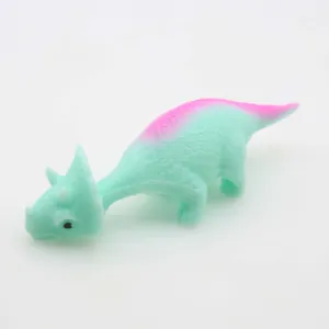 Detailed view of a mint green catapult dinosaur toy featuring a soft pink gradient back