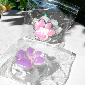 Detail view of pink and purple cat paw squishy toys in clear plastic bags