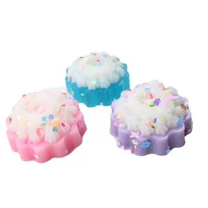 Primer plano de juguetes de cupcakes de colores pastel con crema blanca y purpurina