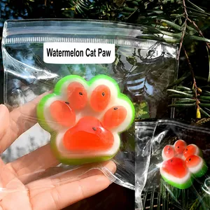 Detailed view of watermelon-themed silicone cat paw squishy stress relief toy in packaging
