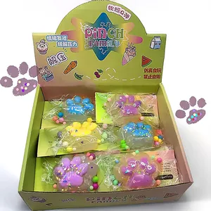 Detailed view of colorful crystal cat paw squishy toys inside a vibrant green display box