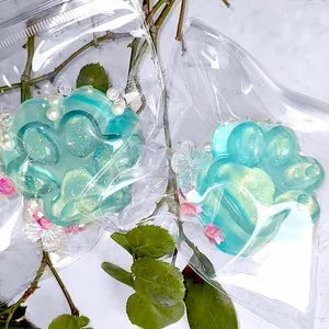 Pair of glittery translucent cat paw squishy toys in clear packaging with charms