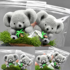 Détail du jouet à presser koala gris avec mousse verte et palmier en emballage transparent