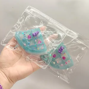 Detailansicht von zwei blauen Waffel-Squishies mit Bären-Anhängern in klaren Plastikbeuteln