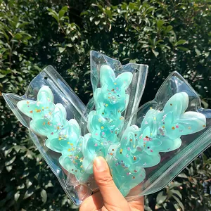 Close-up of mint green butterfly squishy toy in clear packaging for stress relief