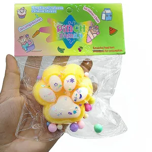 Primo piano di un grande giocattolo squishy a zampa di gatto giallo nella confezione