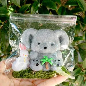 Vue détaillée du jouet Koala duveteux dans un sac d'emballage transparent à fermeture éclair.