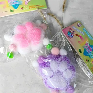 Detailed view of pink and purple flocked silicone cat paw squishy toys in packaging.