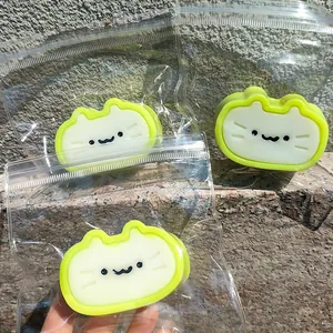 Close-up of three cute cat cheese squishy toys in transparent packaging for stress relief