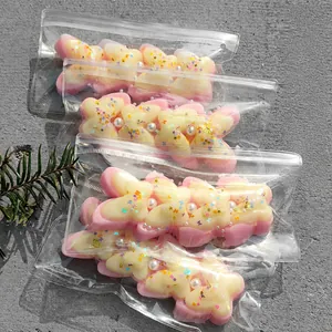Detailed view of pink and cream butterfly-shaped squishy toys with glitter and pearls
