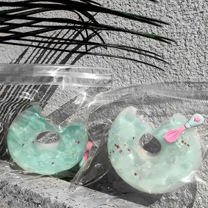 Δύο παιχνίδια squishy σε σχήμα ντόνατ σε διαφανείς σακούλες σε γκρι φόντο