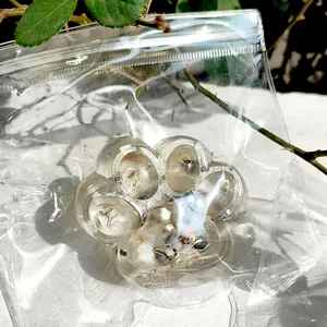 Close-up of a transparent cat paw squishy with glitter inside a plastic bag.