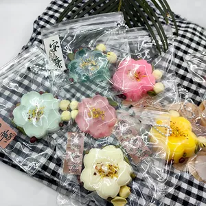 Close-up view of colorful flower-shaped osmanthus cake squishy toys in individual packaging.