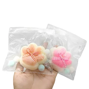 Gros plan de jouets anti-stress en forme de patte de chat dans des sacs plastiques.