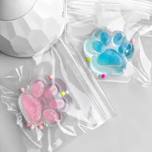 Close-up of pearlescent cat paw squishy toys in clear packaging with colorful beads.