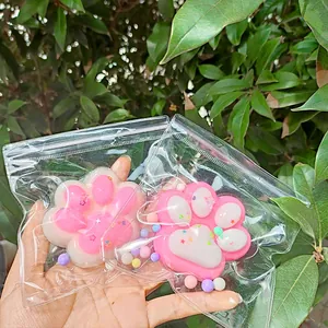 Vue rapprochée de jouets squishy en forme de patte de chat rose et blanc sous emballage clair