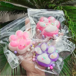 Vue détaillée de jouets squishy patte de chat colorés avec paillettes en emballage zip clair.