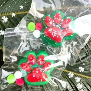 Detailed view of handmade green and red cat paw squishy toys in clear plastic bags