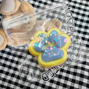 Détail d'un jouet squishy en forme de patte de chat avec des paillettes et des perles.