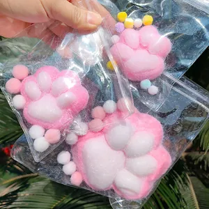 Macro view of three cute pink and white plush cat paw squishy toys in clear bags