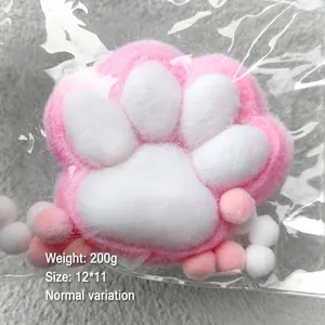 Macro view of a soft pink plush cat paw squishy toy in plastic packaging