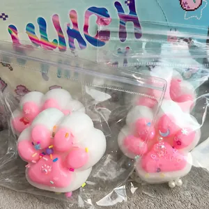 Detailed view of a handmade pink cat paw squishy toy in its professional packaging