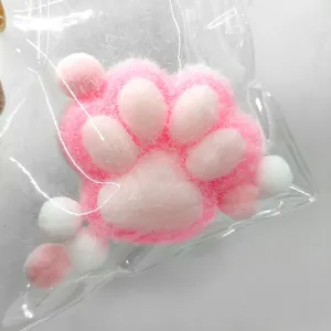 Macro detail of a soft pink and white plush cat paw squishy stress relief toy in a bag