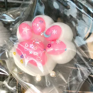 Macro view of the cat paw texture and embedded decorative heart and star charms.