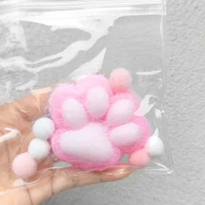 Close-up detail of plush cat paw squishy toy in protective packaging