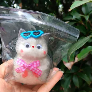 Lindo juguete blandito de gato de dibujos animados gris y blanco con gafas azules en bolsa