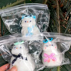 Detalle de tres lindos juguetes squishy de gato blanco en bolsa para aliviar el estrés