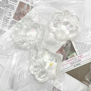 Nahaufnahme von drei transparenten Katzenpfoten-Squishy-Spielzeugen mit Glitzer-Effekt.