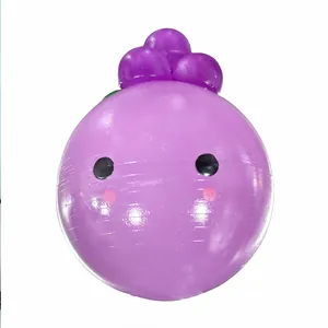 Dettaglio di un giocattolo da spremere a forma di uva viola con un viso carino antistress