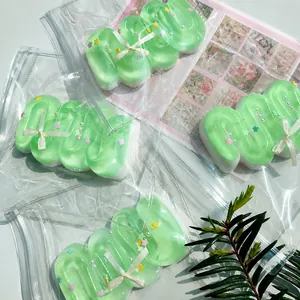 Detailed view of mint green cream bar squishy toy in clear packaging with decorative bow