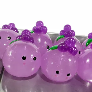 Primo piano di graziosi giocattoli di cristallo a forma di uva viola con faccine