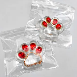 Detailed macro shot of transparent cat paw squeeze toy featuring red gemstone decorations