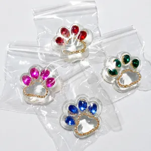 Detail view of transparent cat paw squishy toys with colorful gemstone inserts in bags.