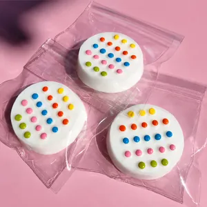 Three colorful silicone disc fidget toys in individual clear packaging on pink background.