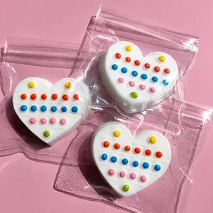 Detailed view of white heart-shaped silicone pop-it toys with colorful dots