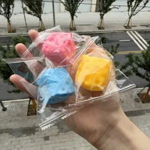 Close-up of three colorful squishy stress balls in individual transparent packaging bags.