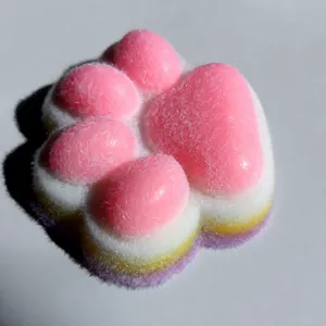 Primer plano de un juguete squishy de pata de gato arcoíris con textura de flocado rosa suave
